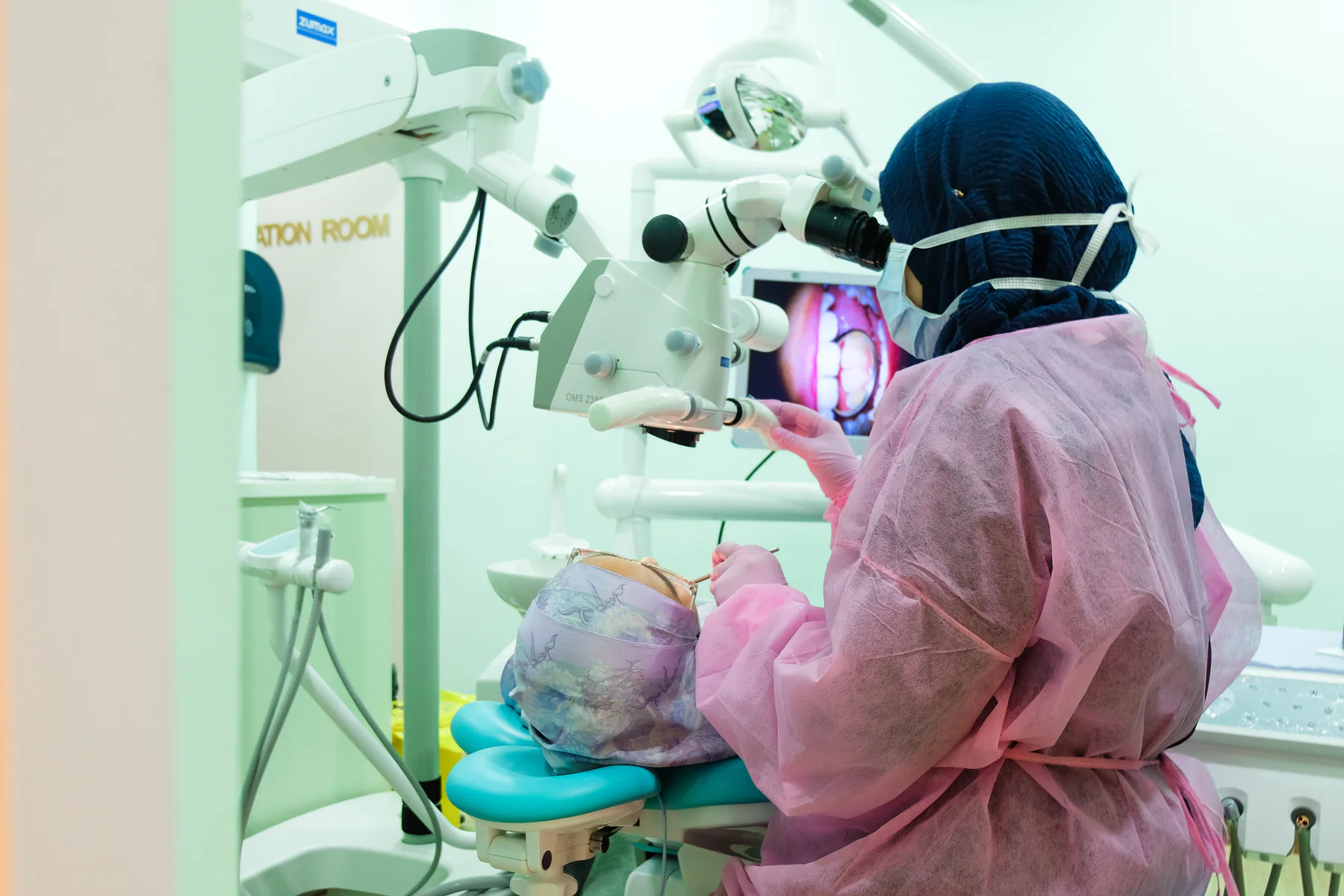 Dentist using a dental microscope during treatment at Kayangan Dental Clinic